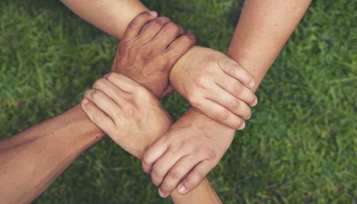 Banner four hands Diverse multiethnic Partner team together. Top View Teamwork group of four multiracial people join hands together. Above view Diversity people hand join four partners team trust